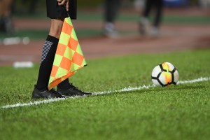 pies de arbitro auxiliar con bandera a cuadros y balon 