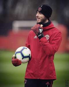 portero del man u con sudadera roja gustes gorro y balon