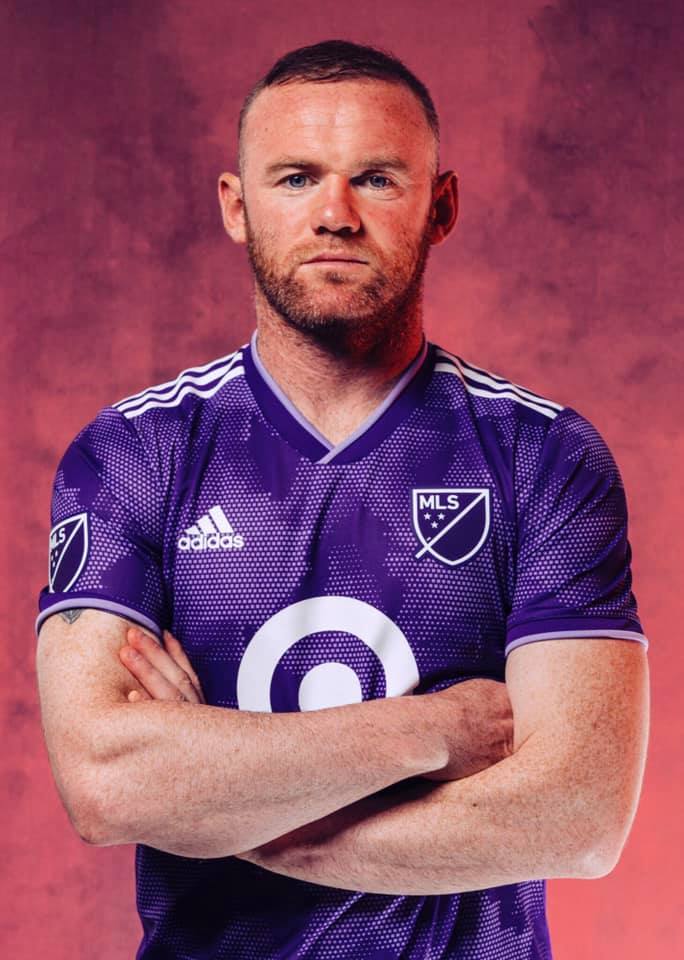 roney de brazos cruzados fondo de humo y playera morada